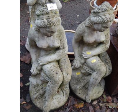 A pair of reconstituted stone garden figures, of semi clad females, with dagger, 60cm high.