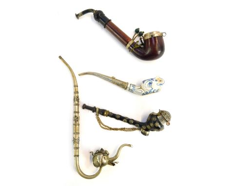 Four pipes, comprising an Eastern opium pipe, carved hardwood pipe, star set pipe and blue and white elephant pipe. (4)