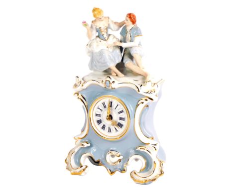 A Royal Dux porcelain Romance mantel clock, on a blue and white rococo form, surmounted by two figures, with pink triangle st