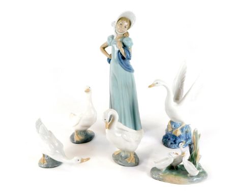 A group of Spanish porcelain figures, comprising geese, and standing lady wearing a bonnet, each with applied green baize cov