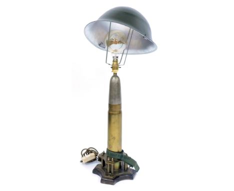 A military style table lamp, comprising a shell case converted to table lamp on a tripod base with applied miniature empty sh