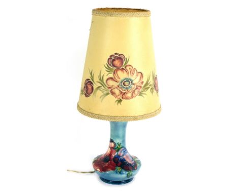 A Moorcroft pottery Anemone pattern table lamp, on a blue glazed ground impressed and painted marks, 27cm high, with cream sh