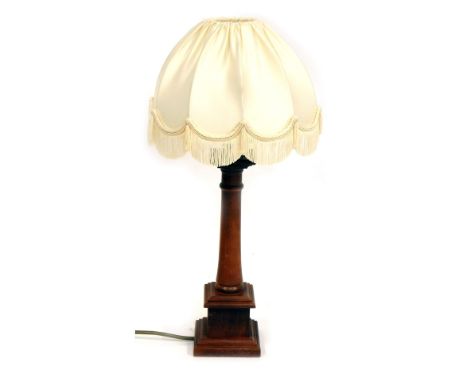 A 1950's carved beech wood table lamp, of column form, with a cream shade, 50cm high.