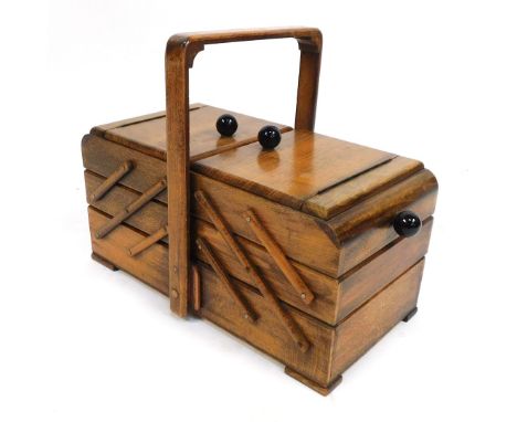 A 1930's cantilever oak sewing box, with ebonised knob on bracket feet, 32cm high.
