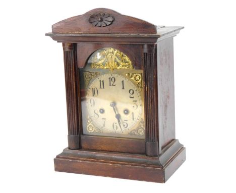 A late 19thC Continental mahogany cased mantel clock, eight day movement with coil strike, with a floral top on reeded column