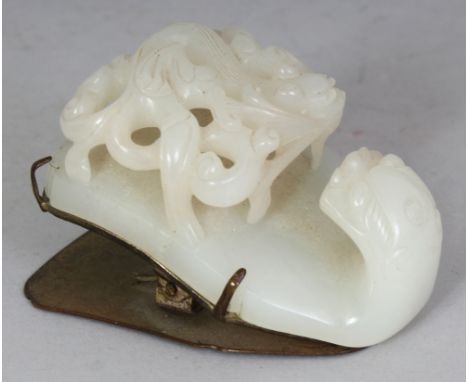 A GOOD QUALITY 18TH/19TH CENTURY CHINESE CELADON JADE BUCKLE, with a silvered copper mount, the jade well carved with a drago