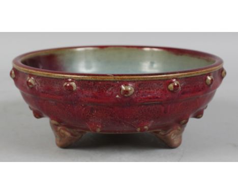 A CHINESE JUN STYLE PURPLE SPLASH CERAMIC BOWL, supported on three ruyi feet, the sides moulded with studs, 7.1in diameter & 