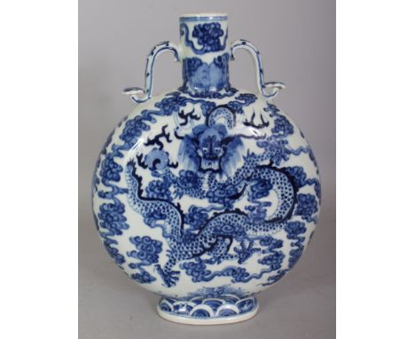 A CHINESE BLUE & WHITE PORCELAIN DRAGON MOON FLASK, with moulded ruyi sceptre handles, the base with a four-character Kangxi 