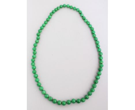 A STRING OF CHINESE APPLE GREEN JADE BEADS, each bead of spherical form and approx. 0.4in diameter.