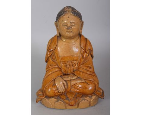 A CHINESE MING STYLE OCHRE GLAZED CERAMIC FIGURE OF BUDDHA, seated in dhyanasana on a lotus plinth, 7.2in high.