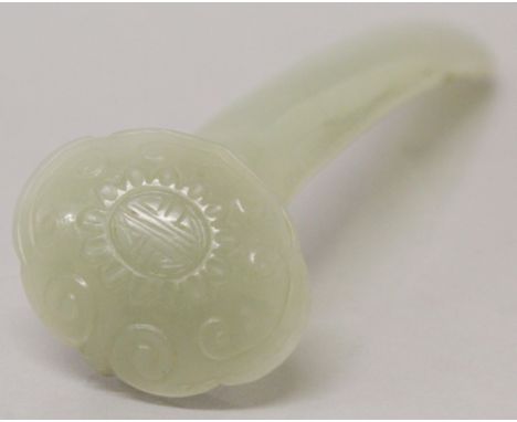 A CHINESE CELADON JADE MODEL OF A RUYI SCEPTRE, its head centred by a Shou symbol, 4.4in long.