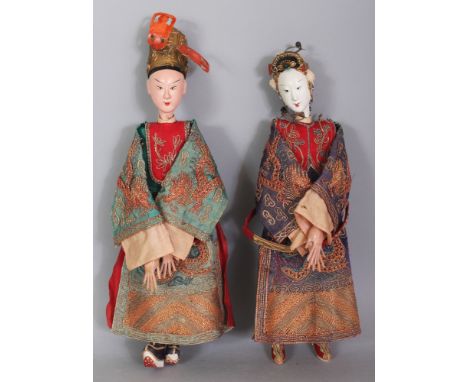 TWO CHINESE DOLLS OF AN EMPEROR AND AN EMPRESS, each in embroidered dragon robes and with painted ceramic heads and hands, 11