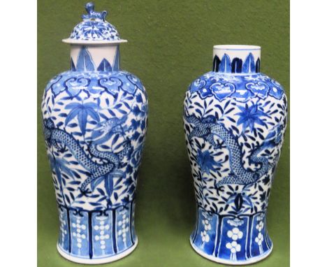 Pair of similar late 19th/early 20th century blue and white ceramic vases, one with cover, decorated with Chinese dragons wit