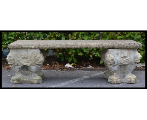 A vintage 20th century reconstituted stone bench comprising of two square planter type ends and stone slab seat. Decorated wi