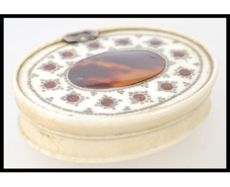 A 18th century Ivory and Tortoiseshell snuff box of oval form with central tortoiseshell cartouche with silver bead work. Mea