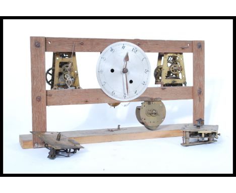 A vintage early 20th century factory slave clock having an open skeleton type movement on wooden plinth base. Please see imag