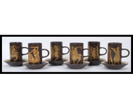 A set of six vintage 20th century Purbeck pottery cups and saucers. The tall cups having gilt decoration of classical scenes.