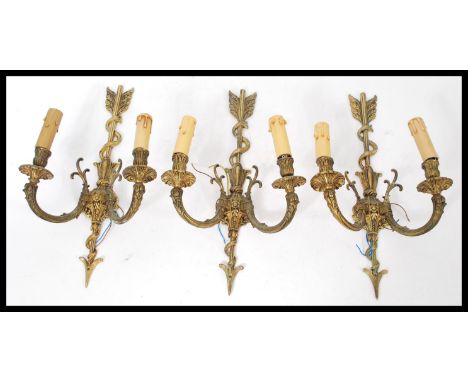 A set of three classical styled brass wall lights having arrow motif to centre.