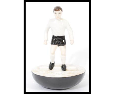 A Royal Doulton Subbuteo ceramic football figurine MCL 12 featuring a player in black and white kit on black and white base. 