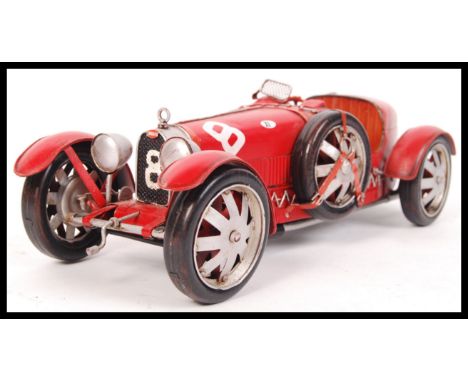 A vintage style tin plate racing car in red with the number 8. Measures approx 35cm in length.