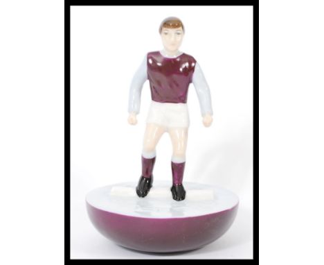 A Royal Doulton Subbuteo ceramic football figurine MCL 12 featuring a player in burgundy and light blue kit on burgundy and w