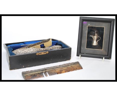 A silver white metal Islamic Dallah coffee pot in a frame along with a cased silver hallmarked vanity set with brushes comb e