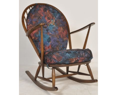 A mid 20th century Ercol beech and elm wood Windsor pattern large rocking chair being&nbsp; raised on sleigh rockers with tur