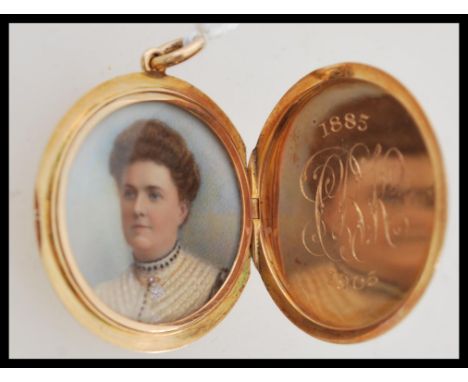 An early 20th century&nbsp; gold metal mourning locket pendant having an engine turned design. Opening to reveal a printed po