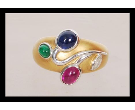 An 18ct yellow gold ruby, emerald, Sapphire and diamond ring in the Art Nouveau manner having cabochon cut stones. Total weig