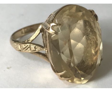 A hallmarked 9ct gold ring having a large central faceted citrine stone set in open gallery setting with prong mounts. Weight