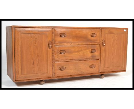 A 20th century&nbsp;light elm and&nbsp;beech wood sideboard by Ercol with three central drawers, the top fitted with cutlery 