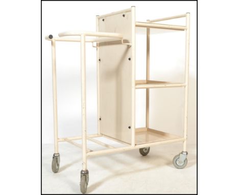 A vintage industrial mid 20th Century tubular framed medical trolley, the tubular framed set with an arrangement of cupboards
