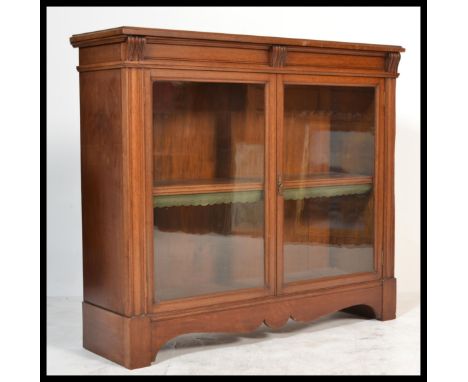 A 19th century Victorian mahogany library bookcase cabinet having shaped bracket feet and apron with twin glazed doors housin