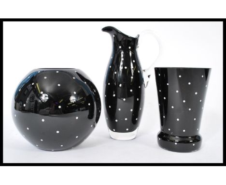Three pieces of vintage 20th century studio glass in deep black glass having white spot design. The lot includes a jug and tw