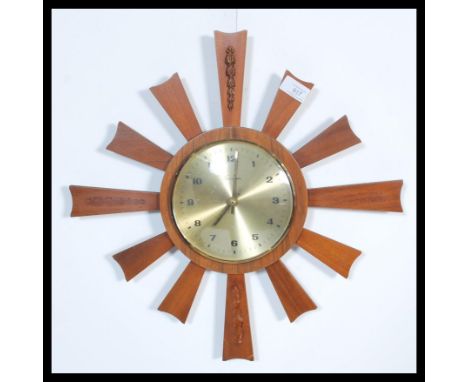 A vintage retro mid century teak starburst sunburst wall clock by Timemaster having a champagne dial with Arabic numeral chap