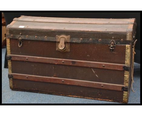 A 19th Victorian brown canvas and bound wooden steamer trunk chest with dome top. The trunk with leather handles and brackets
