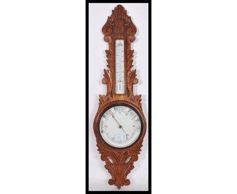 An early 20th century - 1930's milk glass facia oak wall barometer of banjo form having thermometer to the neck. Measures: 92