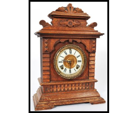 A 19th century American mantel bracket clock having an oak case with gilt dial and white enamel chapter ring with Roman numer