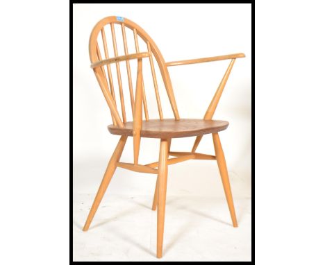 A mid century Ercol beech and elm carver armchair in the Windsor pattern. The shaped elbow rests with turned legs and stretch