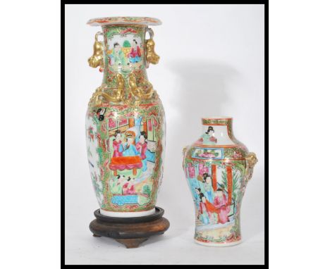 Two 19th century Chinese canton enamel famille verte and rose hand painted vases. One raised on carved wooden sockle base wit