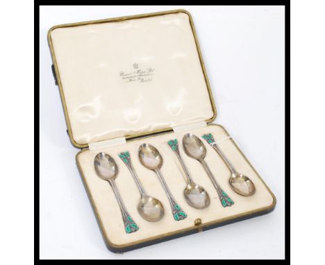 A set of six silver hallmarked and enamel teaspoons having acorn and leaf terminal handles with green enamel leaves. Hallmark