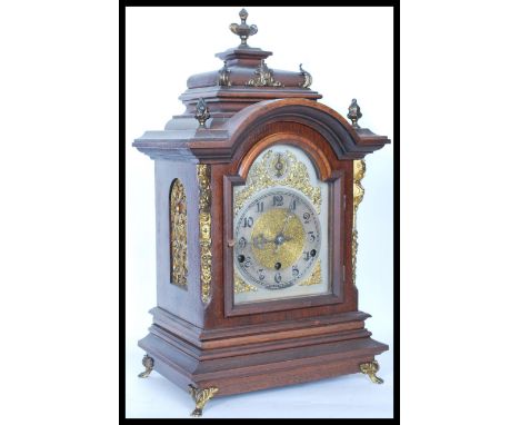 A vintage early 20th century German mantel clock having gilt ormolu acanthus leaf embellishments with acorn and urn finials. 