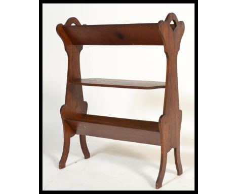 A 19th century Victorian Arts and Crafts oak bookstand trough magazine Canterbury having three tiers raised on splayed legs. 
