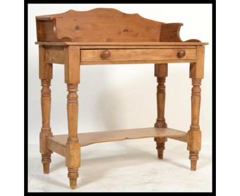 A 19th century Victorian pine gallery top washstand raised on turned and block legs with shelf to lower tier and drawer to fr