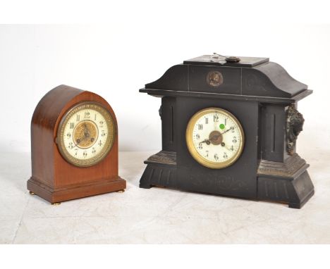 A Victorian slate large 8 day mantel clock with carved masks to the sides, decorative dial complete with key and pendulum tog