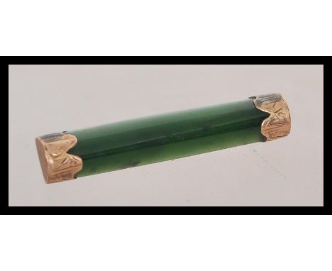 A vintage early 20th century Chinese jade and 9ct gold mounted bar brooch, the ends with scrollwork and engraved decoration. 