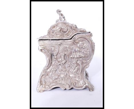 An unusual early 20th century silver plated table top playing card box of scrolled form depicting pagodas and people. Makers 