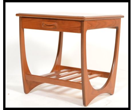 A vintage retro 20th century G-Plan teak side table with slide to front and magazine rack to base. Makers label present.&nbsp