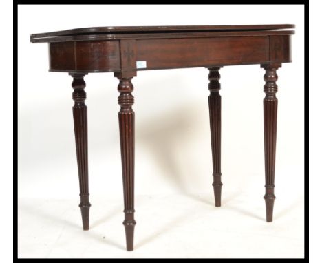 An 18th century George III mahogany tea table being raised on turned legs with fitted frieze having fold over table / games c