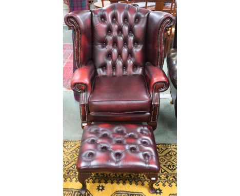 A 20th century oxblood leather button back upholstered Chesterfield style wingback armchair, 106cm high x 93cm wide x 82cm de